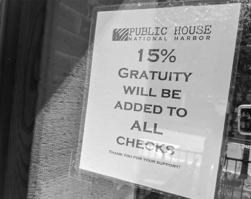 This sign warns customers of the required gratuity that they'll add to the final bill. 