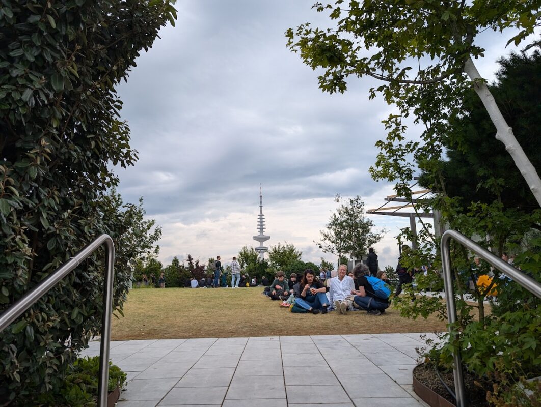 A view of the roof garden at the top of the bunker with Hamburg's iconic Heinrich-Hertz-Turm, a television tower, behind it. The roof garden is accessible to the public.